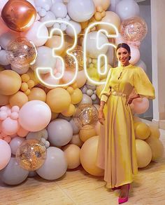 a woman standing in front of balloons and numbers