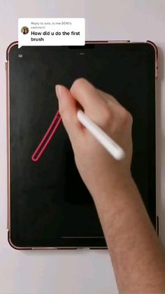 a person is writing on an ipad with a white pen and red marker in their hand