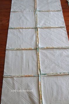 the quilts are laid out on the table to be used as a runner or wall hanging