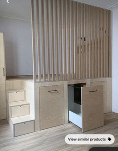 an empty room with stairs and storage cabinets