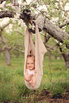 a baby in a hammock hanging from a tree