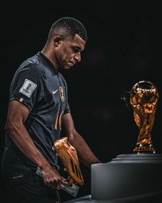 a man holding a baseball glove in front of a golden trophy on a black background