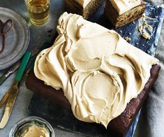 cake with frosting sitting on top of a wooden cutting board next to other dessert items