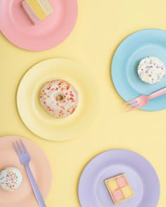 three plates with different types of donuts on them and one has a fork in it