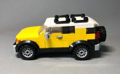 a yellow and black lego car on a gray background