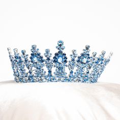 a blue tiara sitting on top of a white pillow