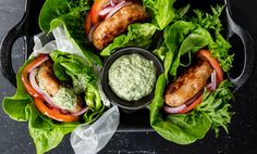 several lettuce wraps with meat and vegetables in them on a black platter