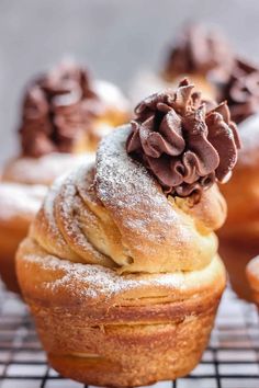 a bunch of doughnuts that are sitting on a cooling rack with powdered sugar