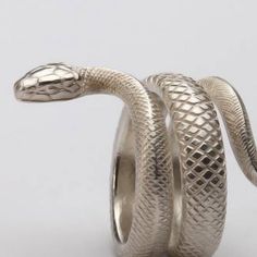 Elegantly sculpted from 925 sterling silver, our serpent ring showcases meticulous craftsmanship, transforming into an art deco masterpiece. The single band design boasts a hood and a gracefully curving tail adorned with a lifelike criss-cross pattern, evoking the texture of a real viper's scales. This enchanting serpent ring is designed to make a statement, gracefully coiling around your finger. It captures the essence of the snake's power, revered in Native American culture. Symbolizing strength and beauty, it perfectly complements gothic and evening attire. Whether for self-adornment or as a gift for any occasion, this ring will leave a lasting impression. Adjustable range6.5 - 12.5 US (53.1 - 68.5mm) Snake Decorations, Silver Snake Ring, Goth Ring, Silver Ring For Men, Serpent Ring, Fashion Rings Silver, Silver Wrap Ring, Snake Ring Silver, Slytherin Aesthetic