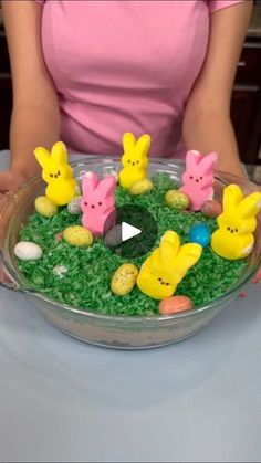 a bowl filled with fake grass covered in peeps and other small plastic animals sitting on top of it