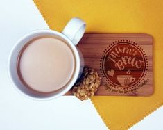 a cup of coffee sitting on top of a wooden coaster