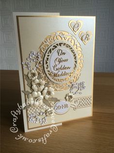 a wedding card with some flowers on the front and side, in gold foiling