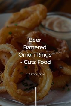 beer battered onion rings - cut's food on a white plate with text overlay that reads beer battered onion rings - cut's food