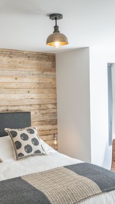 a bed sitting in a bedroom next to a wall made out of wooden planks