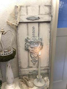 a candle is lit in front of an old cabinet with shoes on it and other items