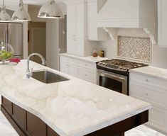 a kitchen with marble counter tops and white cabinets