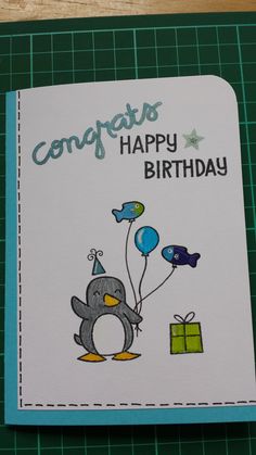 a birthday card with a penguin holding balloons