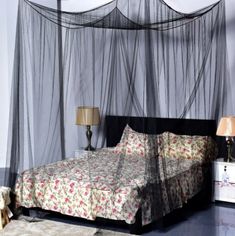 a bed that is in a room with mosquito netting on the wall above it and a lamp next to it