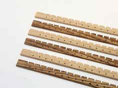 four wooden pegs with holes in them on a white surface