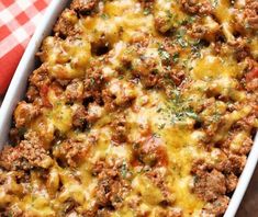 a casserole dish with meat and cheese in it on a checkered table cloth