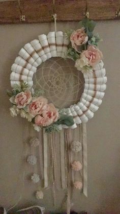 a white wreath with flowers hanging on the wall