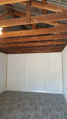 an empty room with white walls and wood floors