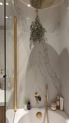 a bathtub with gold faucet and shower head