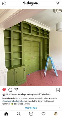 an empty room with green bookshelves and pink carpet on the floor next to a ladder