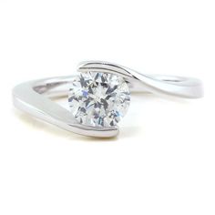 a white gold ring with a round diamond in the center and a twisted band around it