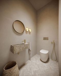 a white toilet sitting next to a sink in a bathroom under a mirror above a faucet