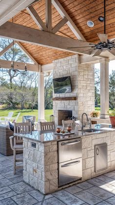 an outdoor kitchen with grill and seating area