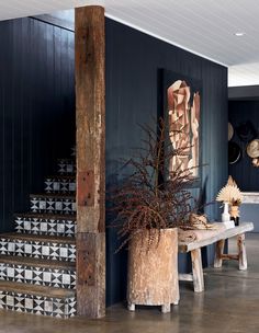 a wooden table sitting next to a set of stairs in a room with blue walls