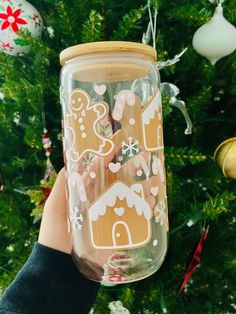 a person holding up a glass jar with gingerbreads on it