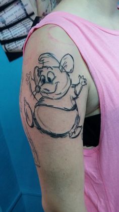 a woman with a cartoon mouse tattoo on her arm