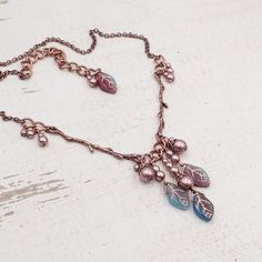 "This handmade necklace features beautifully detailed antiqued copper branches paired with clusters of limited-edition artisan Czech glass leaf beads. Each bead is a swirly mix of transparent purple, transparent teal, and opaque aqua blue glass with a metallic copper wash in the veins of the beads. I finished the clusters with metallic Czech glass faux pearl beads. --------------------------------------------------------------------------------------------- Dimensions and details: - The drop of Cheap Elegant Czech Glass Necklaces, Cheap Czech Glass Necklaces With Polished Beads, Luxury Czech Glass Necklaces For Gifts, Luxury Elegant Czech Glass Necklaces, Cheap Handmade Czech Glass Beaded Necklaces, Cheap Handmade Czech Glass Necklaces, Cheap Adjustable Czech Glass Necklaces, Luxury Elegant Necklace With Czech Glass, Luxury Czech Glass Beaded Necklace