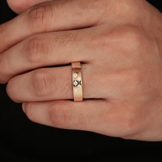 a person's hand with a gold ring on their left and two diamonds in the middle