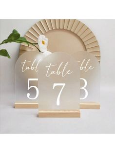 the table numbers are placed on top of each other in front of a plate with a flower