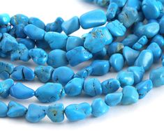 several pieces of turquoise colored beads on a white surface