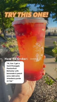 a person holding up a cup with red liquid in it that says try this one