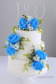 a white cake with blue flowers and the number ten on top