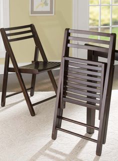 two wooden chairs sitting next to each other on a carpeted floor in front of a window