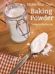 a wooden table topped with a glass jar filled with baking powder and a spoon next to it