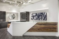 the interior of an office building with white walls and wood slats on the counter