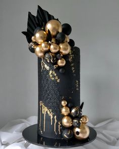 a black cake with gold decorations on top