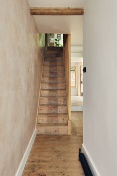 an empty hallway with wooden steps leading up to the second floor