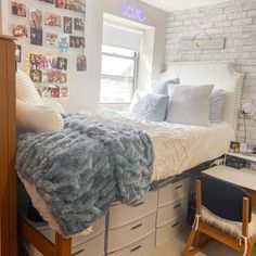 a bedroom with white brick walls and lots of pictures on the wall above the bed