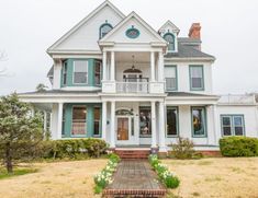 a large white house with green trim on the front