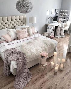 a bedroom with white and pink decor on the walls, wood flooring and a large bed