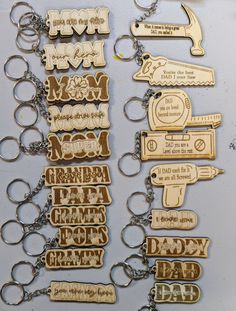 many different key chains are hanging on a white wall with words written in wooden letters that spell out the word mom and dad