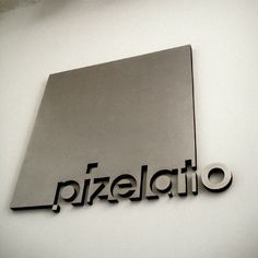 the logo for pizalato is shown in black and silver on a white wall